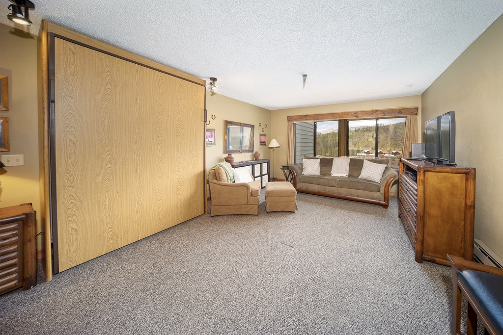 Your spacious living room features comfortable seating and a large TV, perfect for relaxing after mountain adventures.