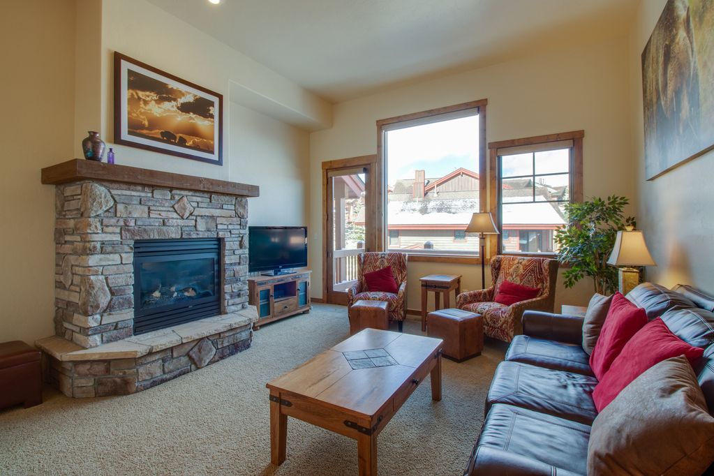 Sink into plush seating by your stone fireplace, where warm lighting and mountain views create the perfect retreat.