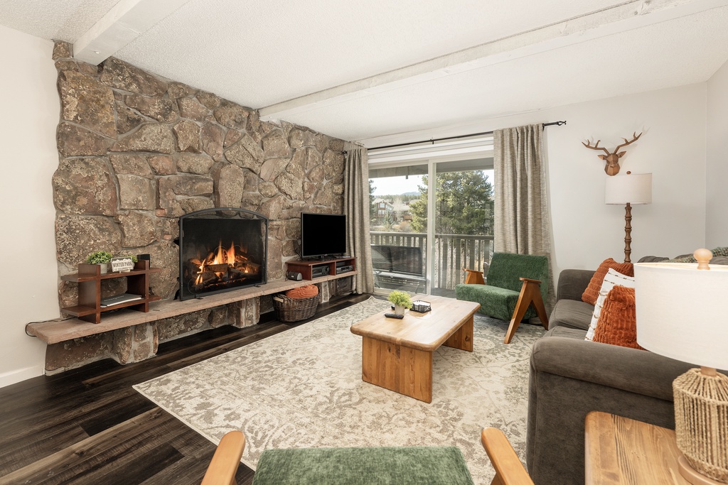 Unwind by your crackling stone fireplace in this cozy living room, where rustic charm meets modern comfort for perfect mountain getaway evenings.