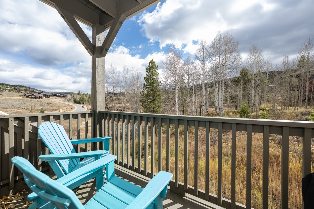 Relax on your private balcony with turquoise Adirondack chairs and sweeping mountain views—your perfect retreat spot when you stay at Kicking Horse Buckskin 3-205.