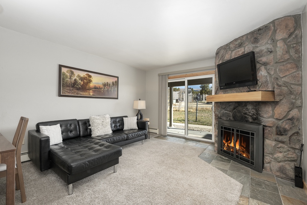 Cozy up by your crackling stone fireplace while enjoying views from your comfortable sectional sofa in this inviting living space.