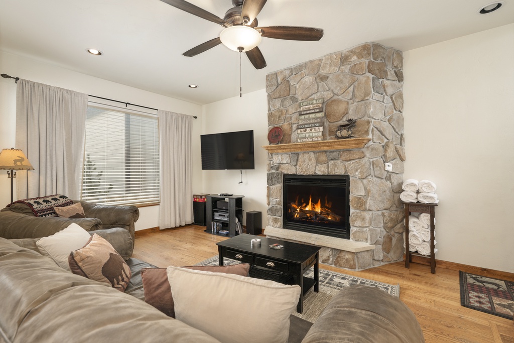 Unwind in this cozy living room where the stone fireplace creates a warm ambiance and plush seating invites you to relax completely.