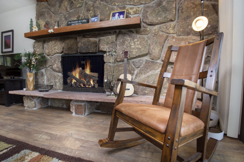 Settle into your cozy leather rocking chair beside the crackling stone fireplace for perfect evenings of warmth and relaxation.