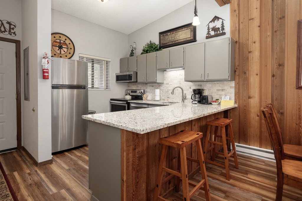 Your fully equipped kitchen features granite counters, stainless steel appliances, and cozy bar seating—perfect for morning coffee or casual meals together.