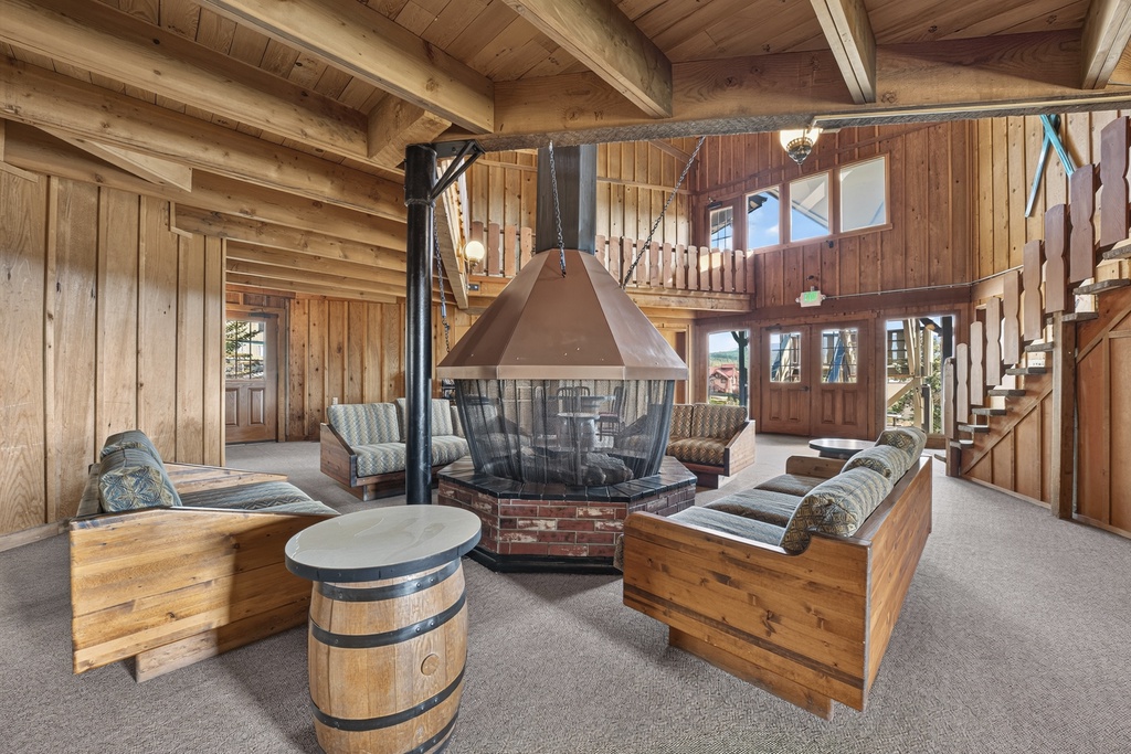 Gather around the unique central fireplace, where rustic wood meets cozy comfort. Your mountain retreat features soaring ceilings with exposed beams and a welcoming loft overlooking the spacious living area.