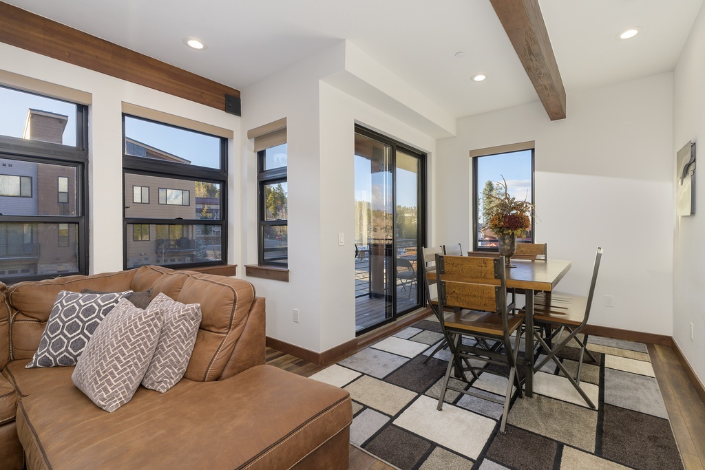 Relax in this bright, modern living space featuring exposed wood beams and a private balcony where you can unwind after exploring the area.