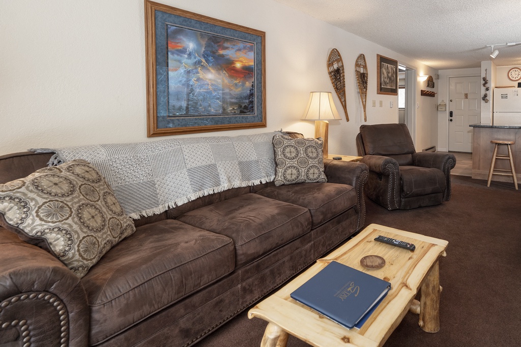 Sink into plush leather seating where rustic mountain artwork and warm lighting create your perfect retreat for evening relaxation.