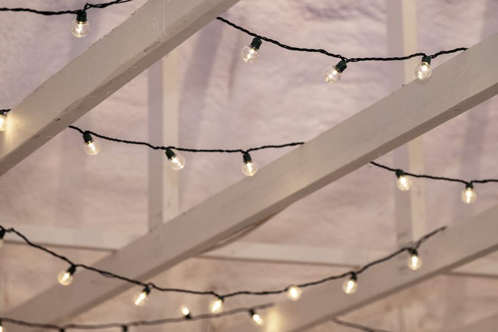 Charming string lights create a magical ambiance above your outdoor space, perfect for evening dining under the stars.