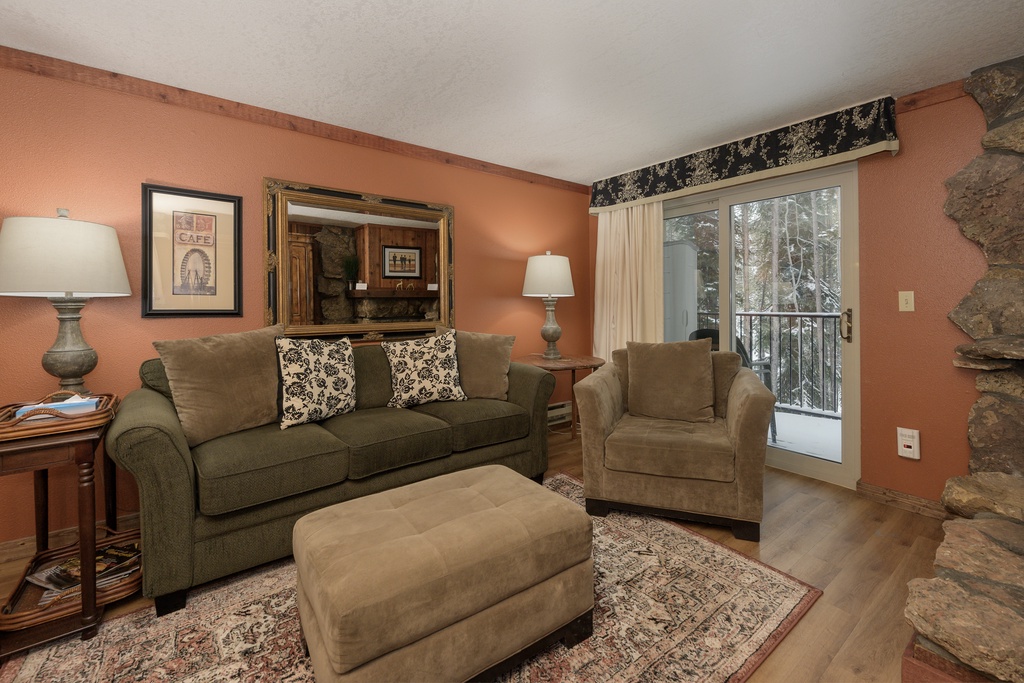 Cozy up in your inviting living room with plush seating and warm mountain views through the sliding glass door.