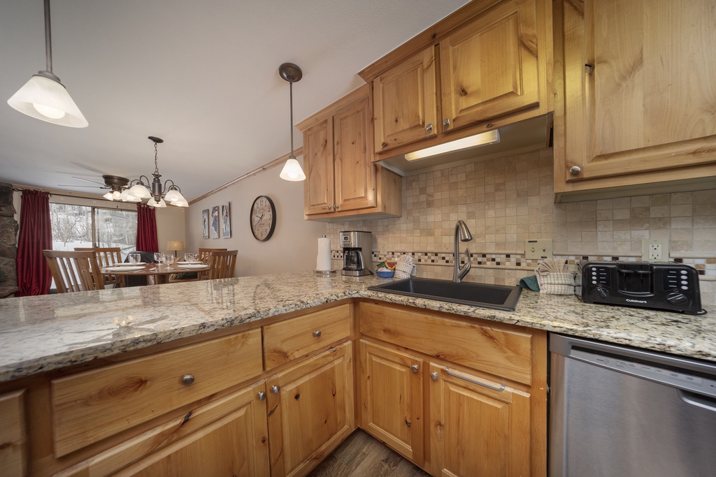 Your fully equipped kitchen features granite countertops and warm wood cabinets, perfect for preparing meals during your stay.