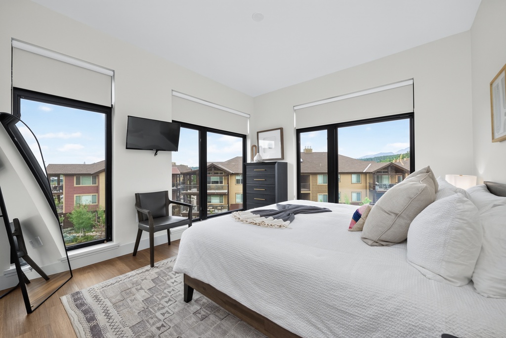 Sink into plush bedding and wake up to mountain views framing your bright, airy bedroom—a peaceful retreat after your day exploring.