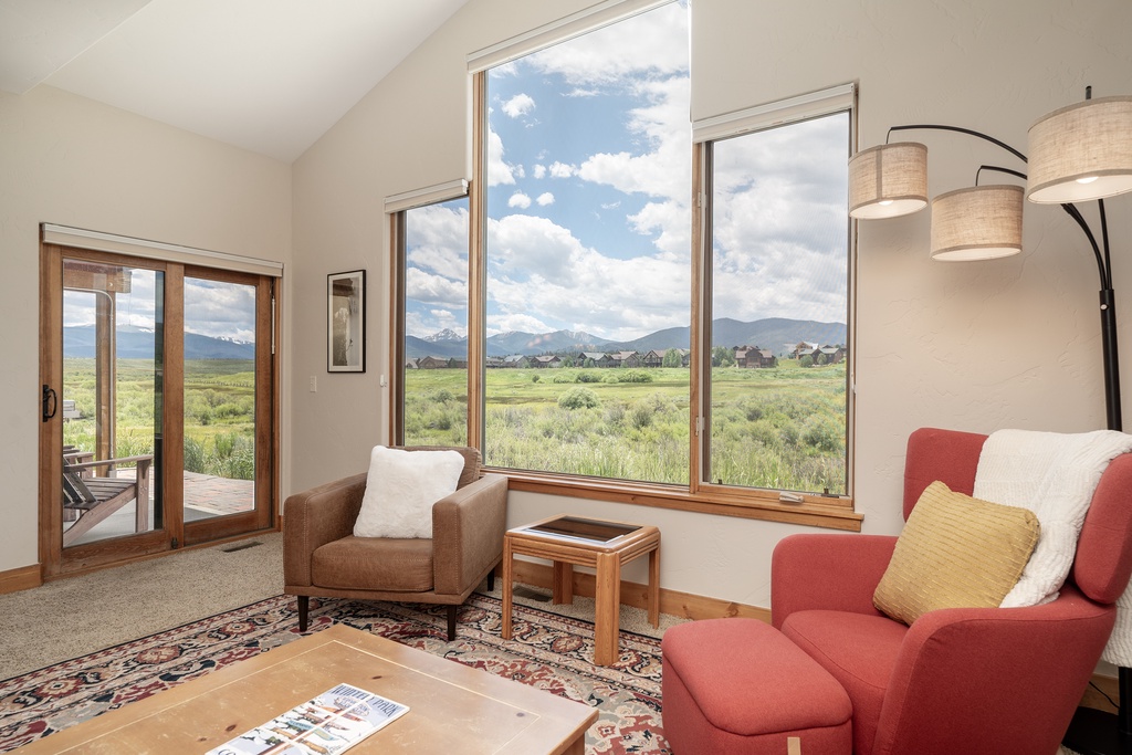 Unwind in your bright living space with sweeping mountain views through floor-to-ceiling windows, perfect for morning coffee moments.
