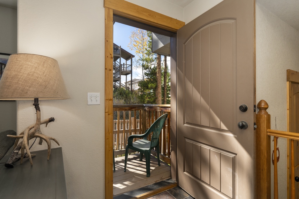 Step through your door onto your private balcony where a cozy chair awaits, perfect for morning coffee or watching the trees sway in the breeze beyond.
