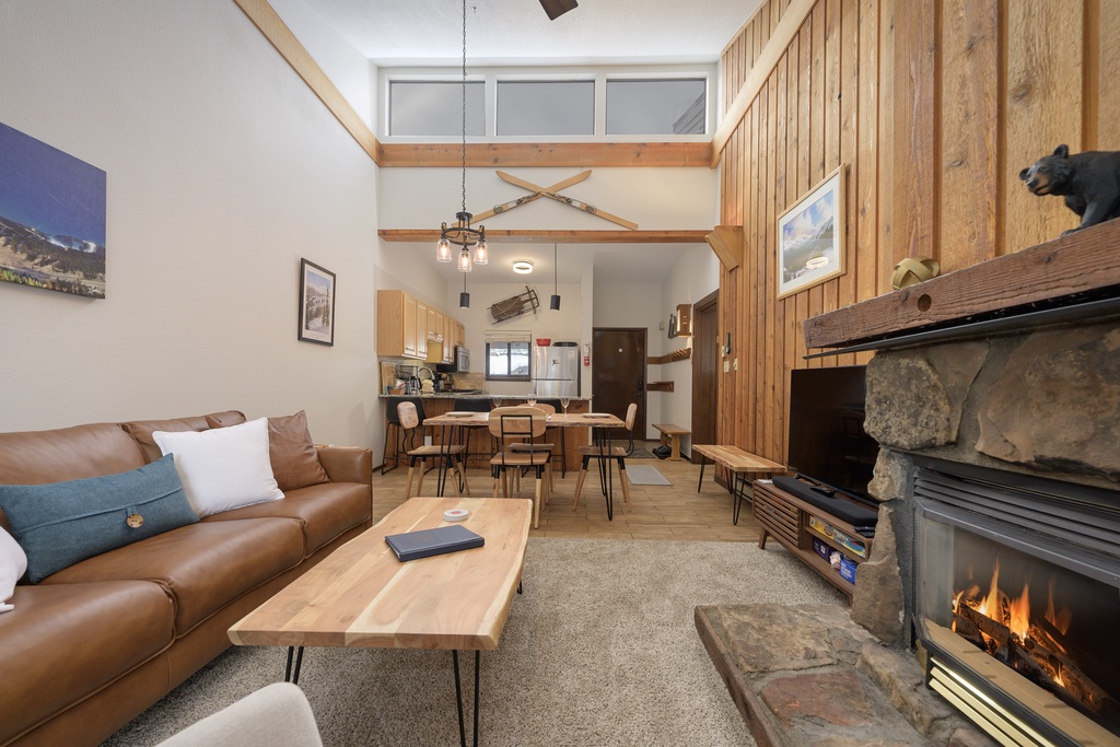 Cozy up in your alpine living room with crackling fireplace, leather sofa, and mountain views from the loft.