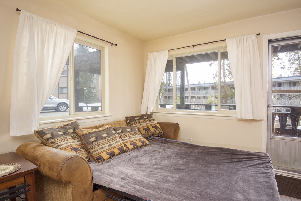 Sink into this cozy daybed surrounded by natural light from corner windows, perfect for afternoon naps or reading.