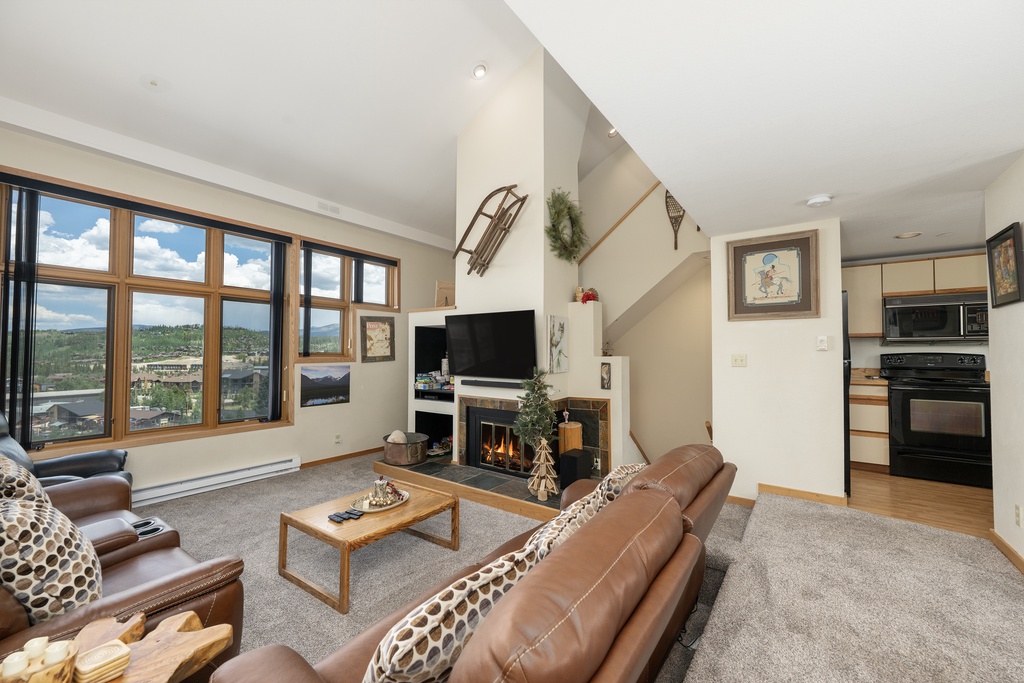Relax by your crackling fireplace while taking in stunning mountain views through expansive windows in this bright, open living space.