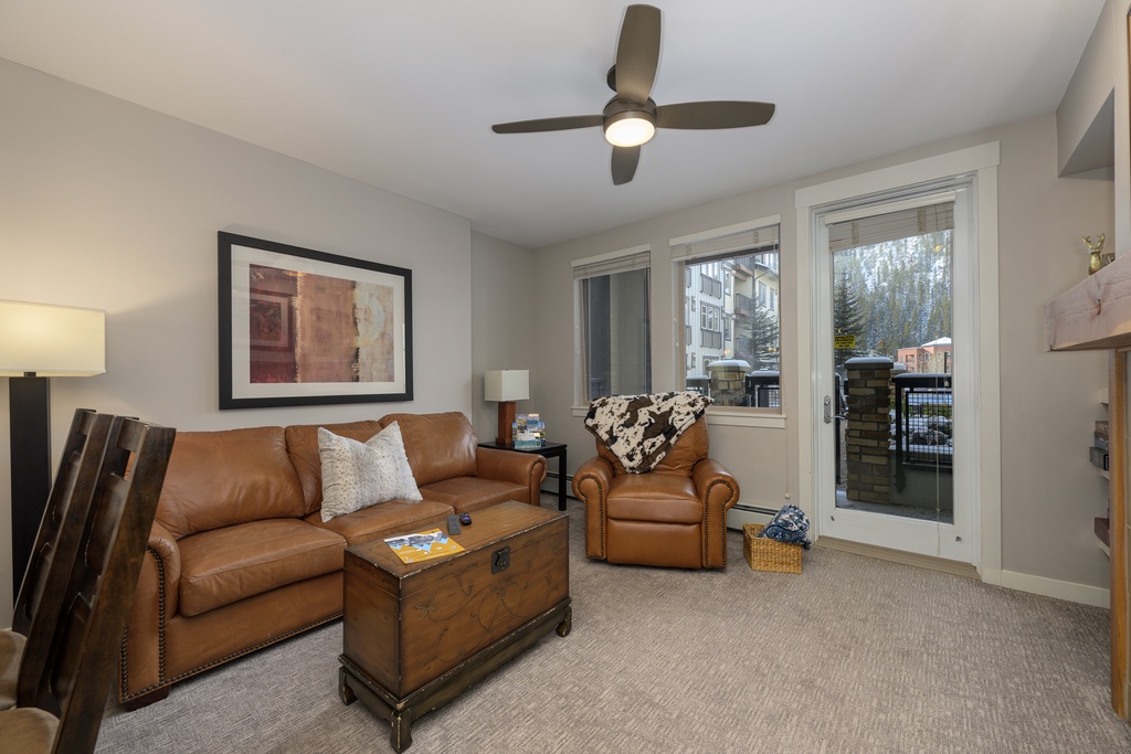 Relax in your cozy living room with plush leather seating and mountain views through the sliding patio doors.