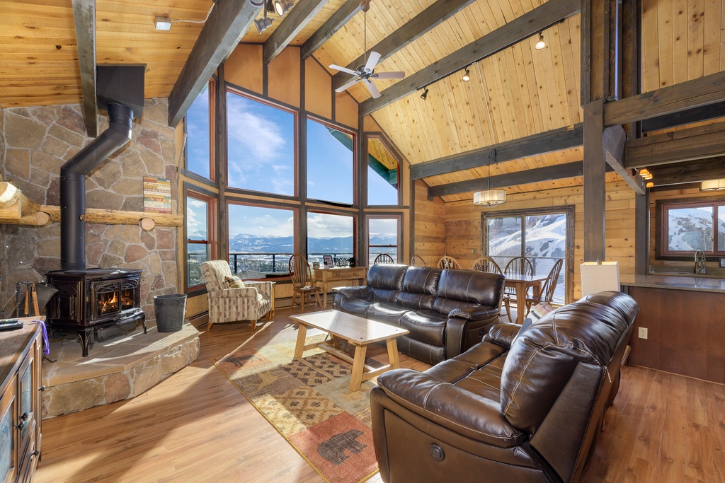 Cozy up in this stunning mountain retreat with soaring ceilings, leather seating, and breathtaking views through floor-to-ceiling windows.
