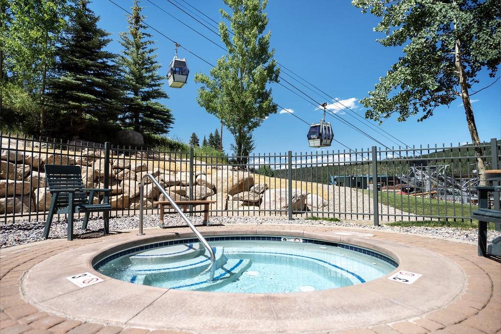 Luxurious hot tub in a mountain resort setting, with gondola lift access and scenic alpine views perfect for relaxation after a day of adventure.