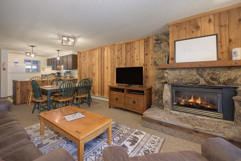 Cozy up by your stone fireplace in this warm living space with rustic wood accents and open kitchen for mountain memories.