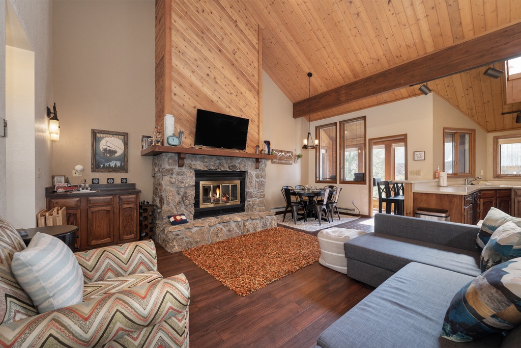 Unwind by your crackling stone fireplace in this cozy living space with soaring wood ceilings and mountain charm.