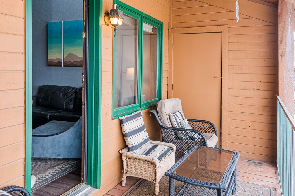 Unwind on your private balcony at 643 SilverCreek Inn with comfy seating and charming green-trimmed doors leading into your cozy retreat.