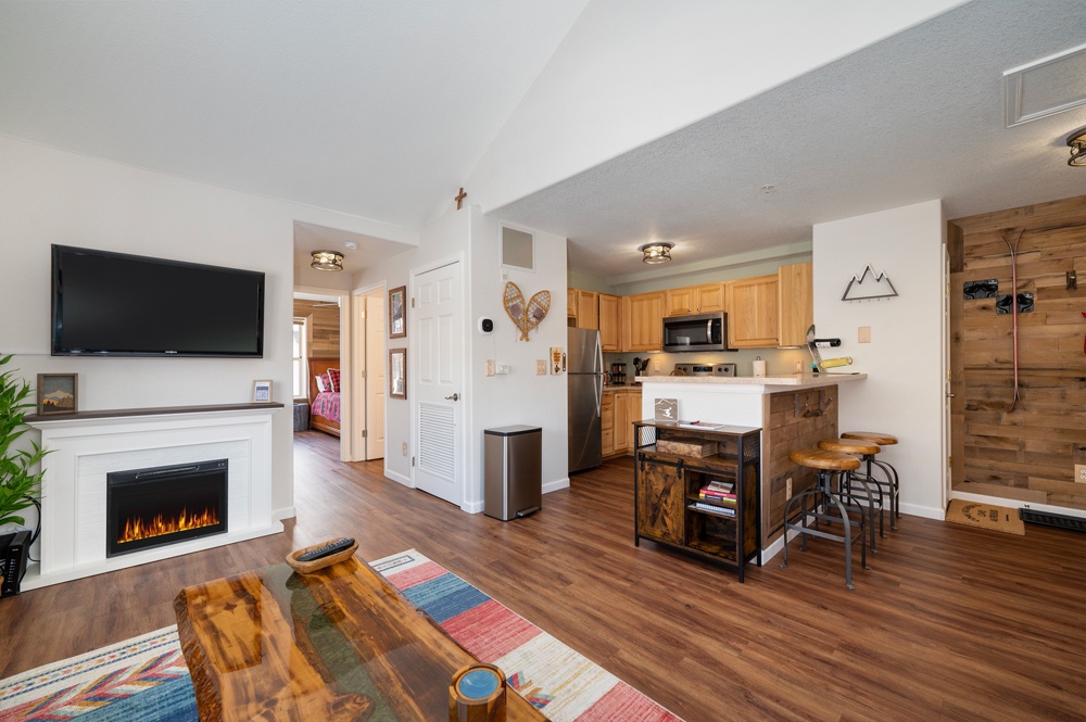 Step into your cozy mountain retreat where warm wood tones meet modern comfort. The open layout flows from fireplace to kitchen, perfect for your relaxing getaway.