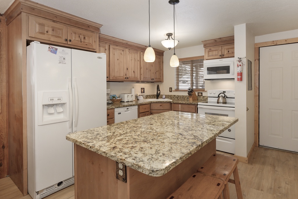 Your fully equipped kitchen features granite countertops, warm wood cabinets, and modern appliances for memorable home-cooked meals.