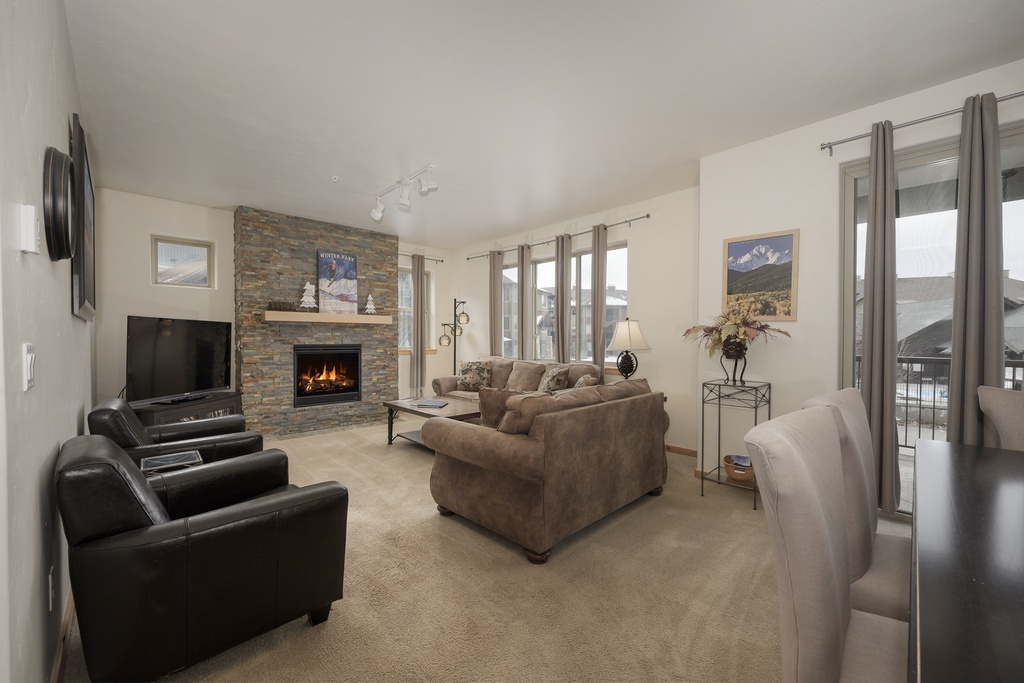 Unwind in your spacious living room with crackling fireplace, plush seating, and mountain views through expansive windows.