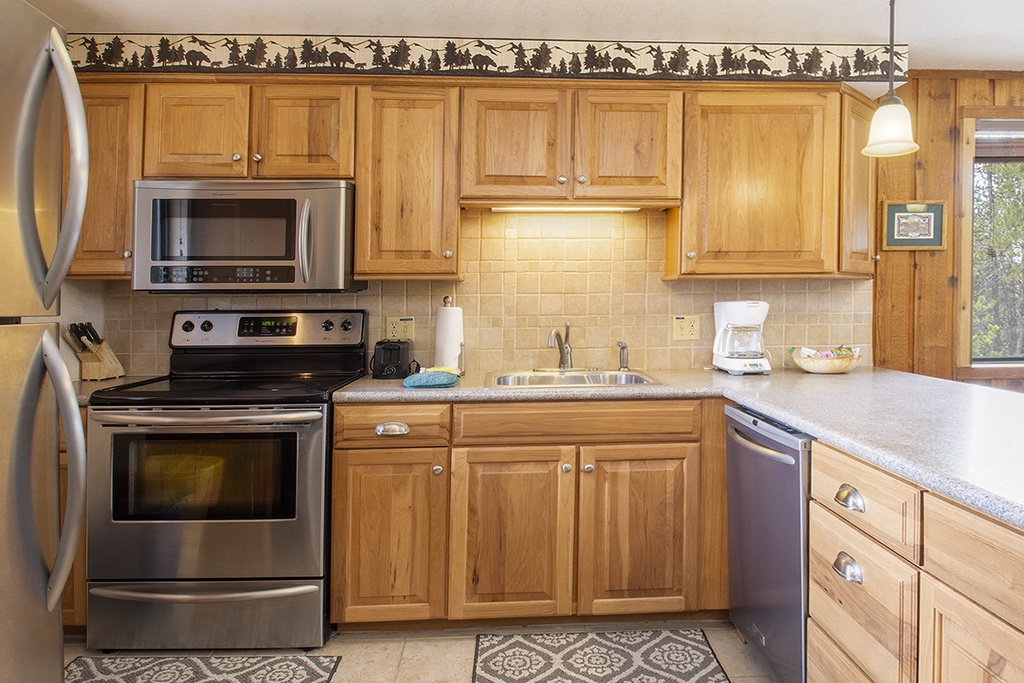 Your fully equipped kitchen features stainless steel appliances and warm wood cabinetry, perfect for preparing memorable meals during your stay.