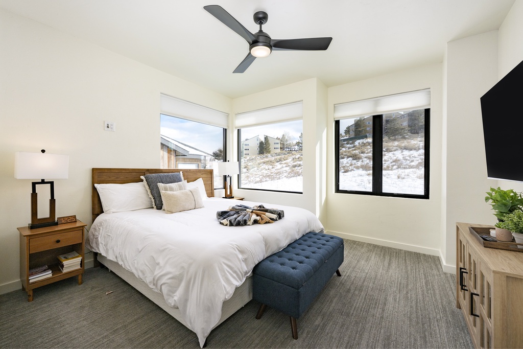 Wake up to stunning mountain views from your cozy bedroom at Base Camp Townhome 106, complete with plush bedding and modern amenities for the perfect winter retreat.