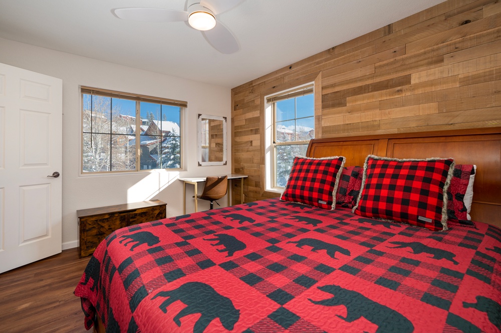 Wake up to stunning mountain views in your cozy bedroom, complete with rustic wood accents and charming buffalo plaid bedding that perfectly captures alpine charm.