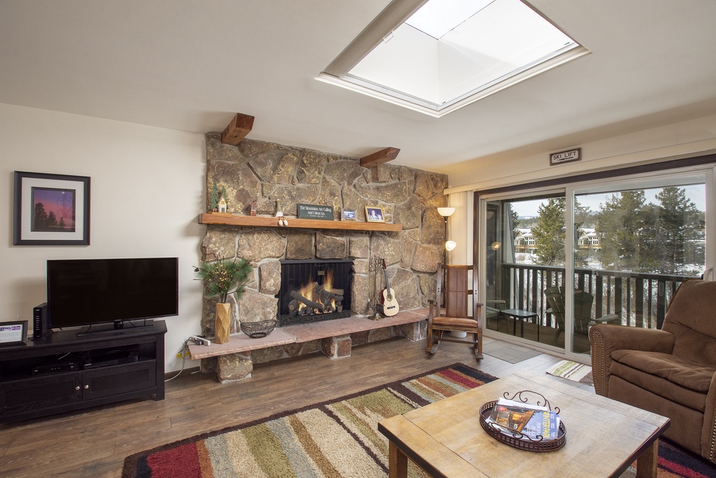 Cozy up by your stone fireplace while natural light pours through the skylight, creating the perfect mountain retreat atmosphere.