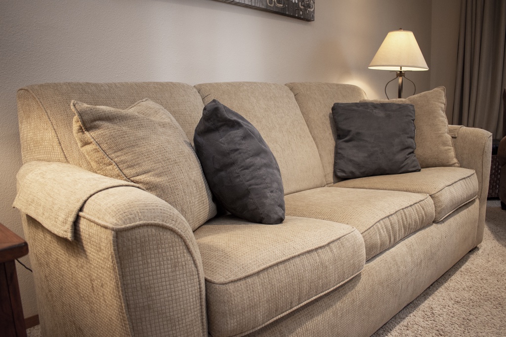 Sink into this plush sofa with soft throw pillows and warm lamp lighting for your perfect evening unwind.