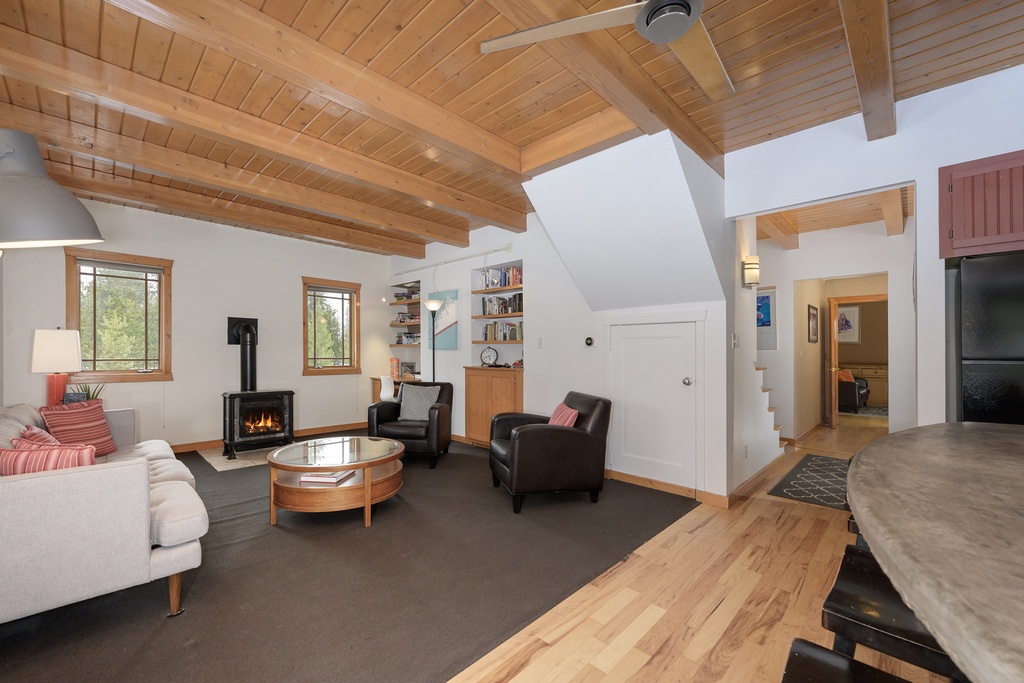 Relax in your cozy living room with soaring wood beam ceilings, crackling fireplace, and comfortable seating for memorable evenings together.