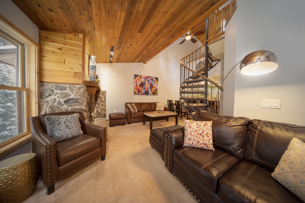 Sink into plush leather seating by your stone fireplace, where wood-beam ceilings and spiral stairs create a cozy mountain retreat.
