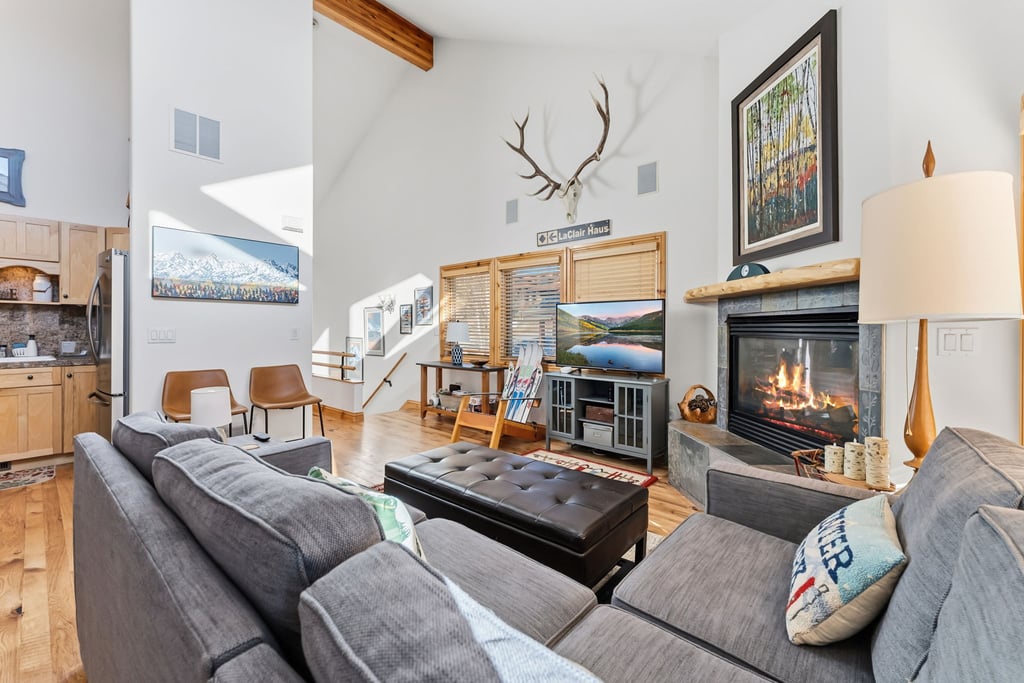 Sink into plush sofas by the crackling fireplace while mountain views fill your windows in this cozy living space.