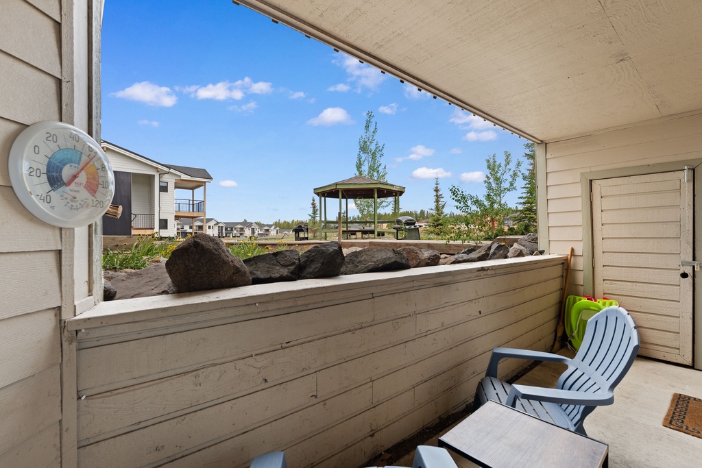 A covered patio offers neighborhood views with a gazebo, natural rock features, and outdoor seating for relaxing on sunny days.