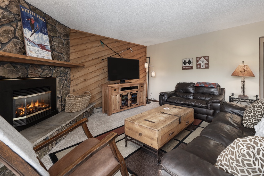 Cozy up by your crackling fireplace while watching your favorite shows in this welcoming living room with rustic charm.