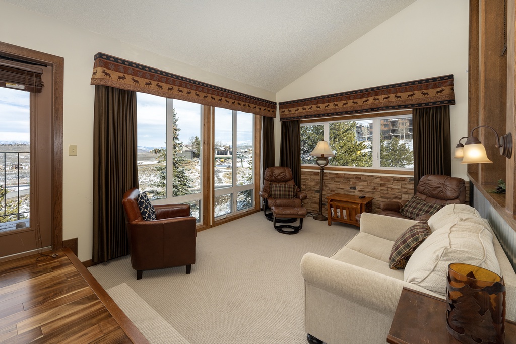 Sink into plush seating while gazing at snow-capped mountain views through expansive windows in your cozy living room retreat.
