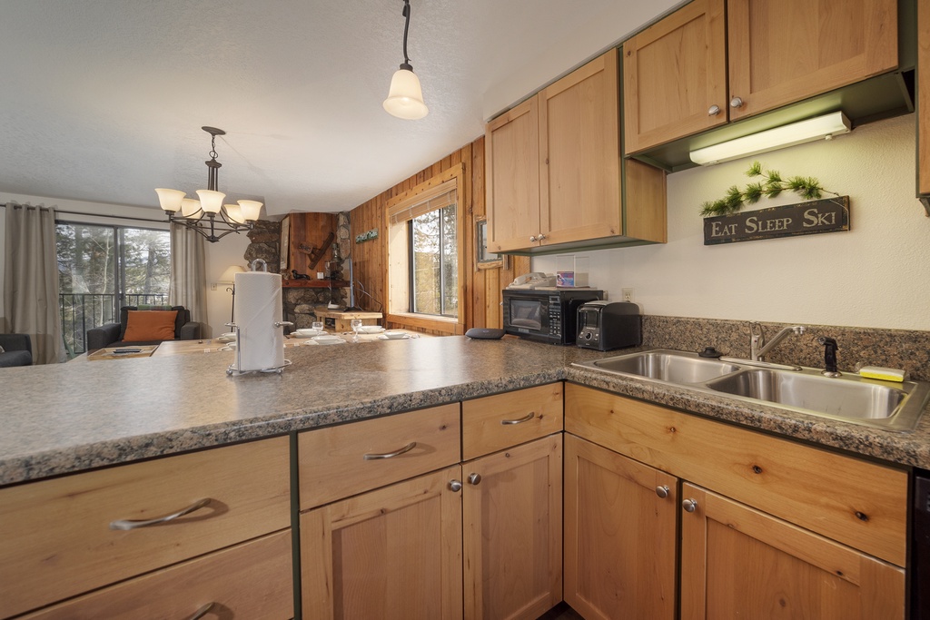 Your fully equipped kitchen features granite countertops and warm wood cabinets, perfect for preparing meals after your mountain adventures.