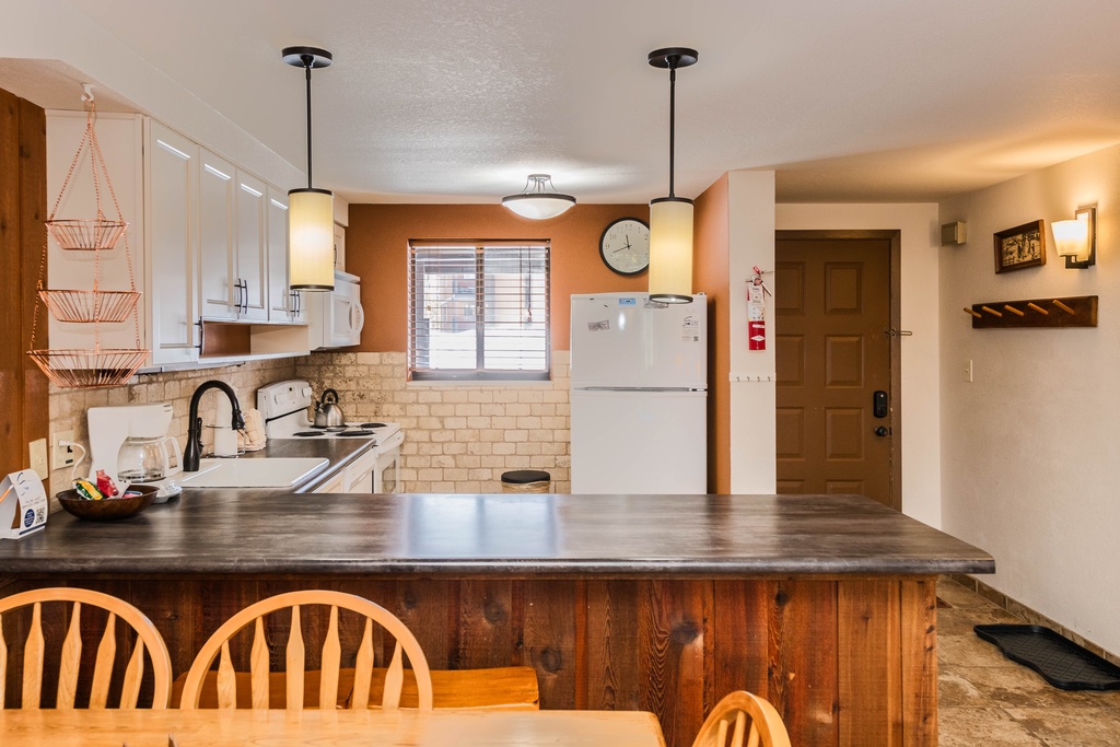 Your fully equipped kitchen features warm wood counters, modern appliances, and pendant lighting—perfect for preparing meals during your stay.