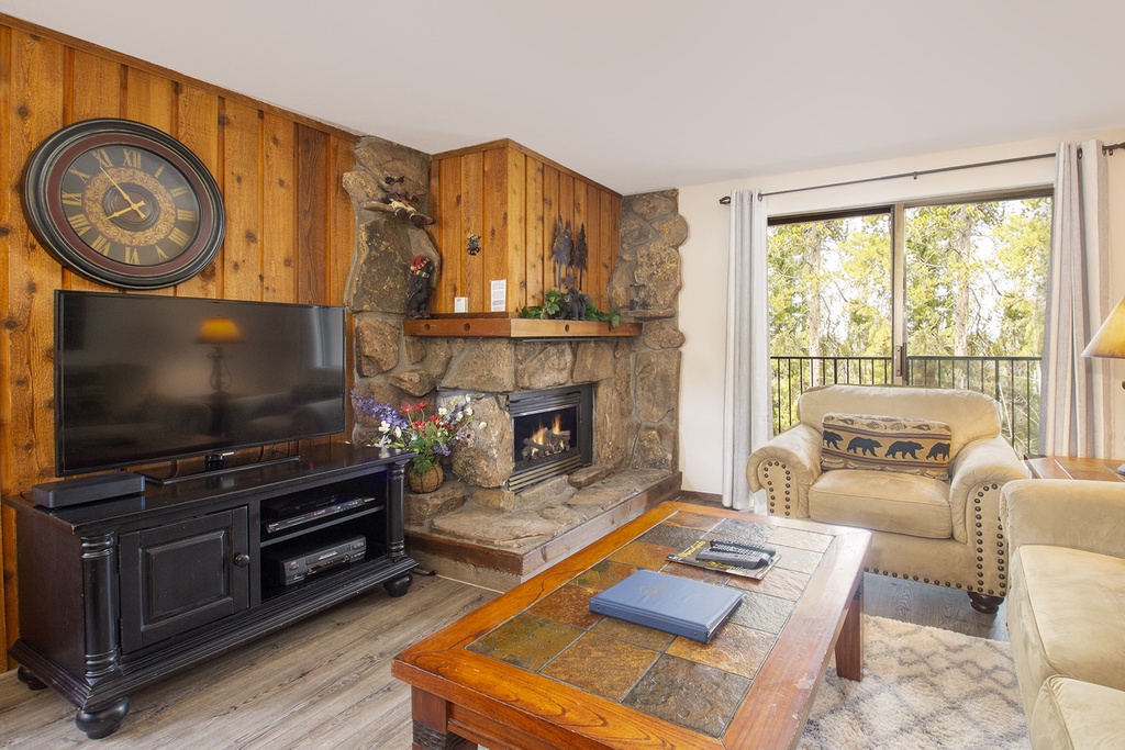 Your cozy living space features a stone fireplace and woodland views for perfect mountain retreat evenings.