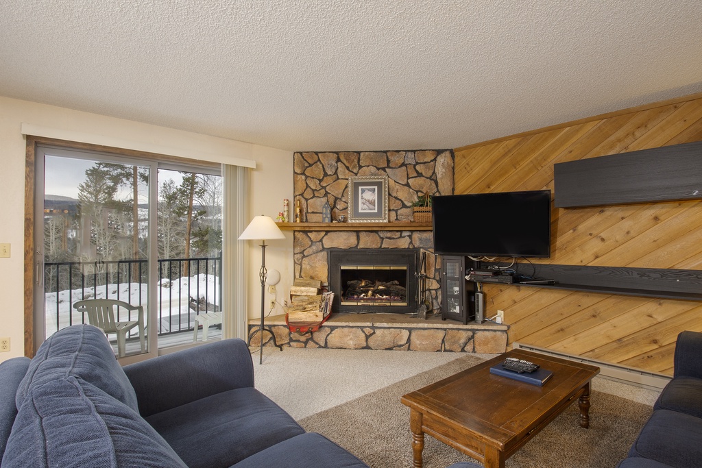 Cozy up by your stone fireplace in this inviting living space, complete with mountain views from your private balcony.