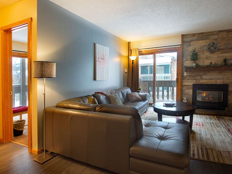 Sink into plush leather seating by your cozy fireplace, where mountain views frame perfect evenings of relaxation and warmth.