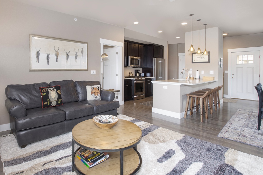 Sink into your cozy leather sofa while enjoying the open-concept design that seamlessly connects your living space to the modern kitchen.
