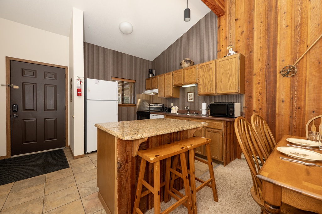 Prepare your favorite meals in this warm, wood-paneled kitchen with granite counters and everything you need for a cozy mountain retreat.