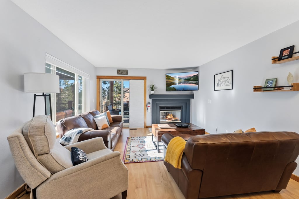 Cozy up in your spacious living room with plush seating and a warm fireplace, perfect for relaxing evenings.