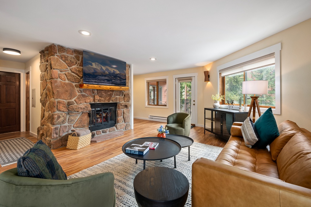 Sink into plush leather seating by your crackling stone fireplace, where mountain views and warm lighting create the perfect retreat.