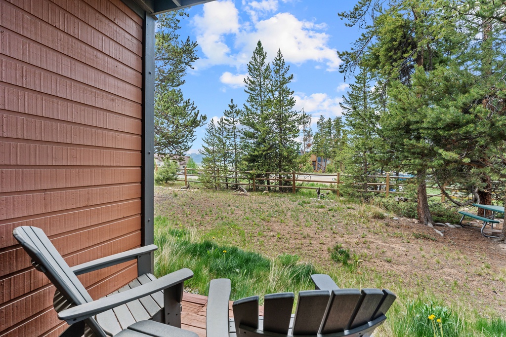 A private mountain retreat nestled among towering pines, offering serene views and peaceful outdoor space near a neighboring property.